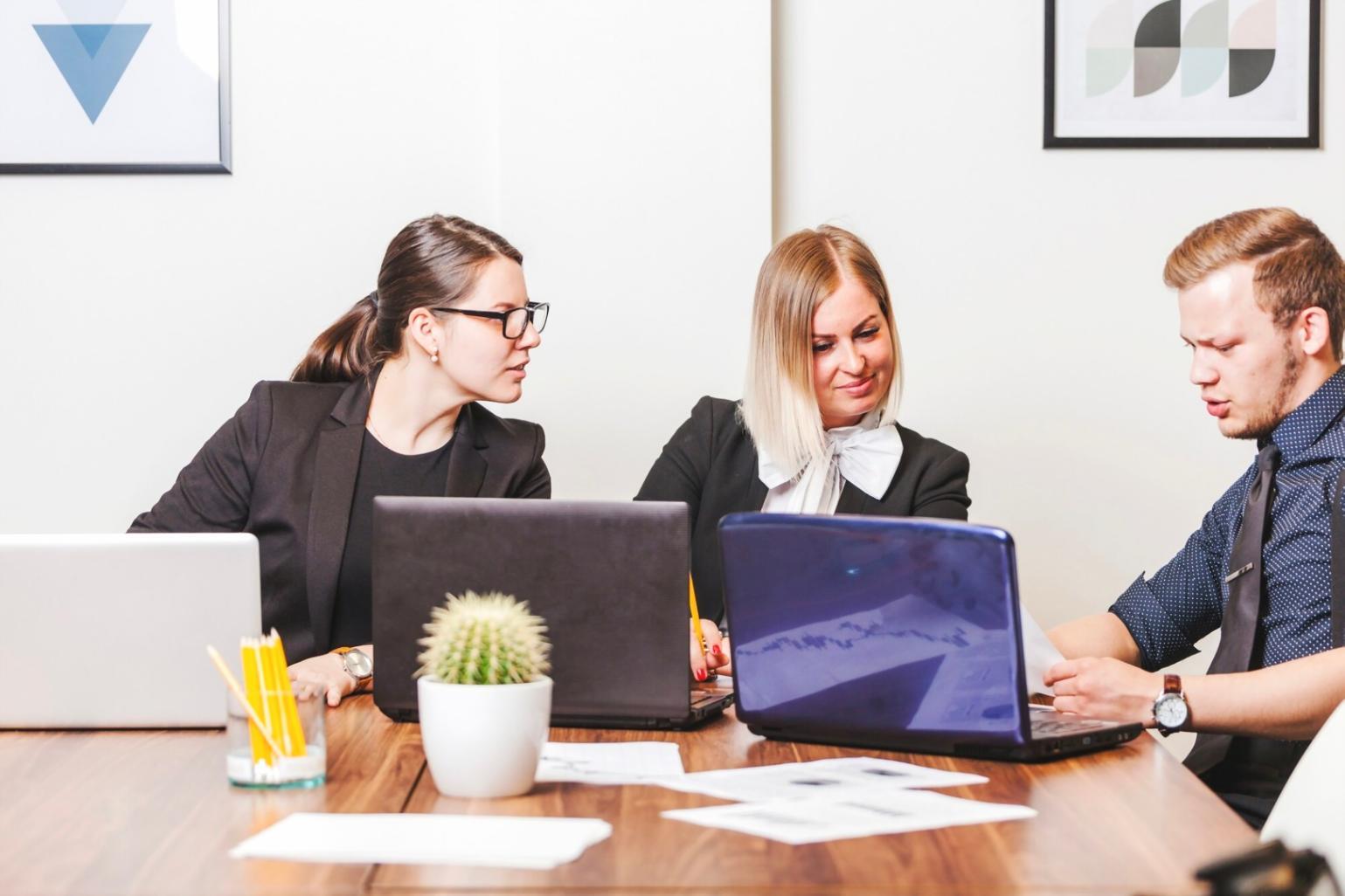 Groupe de personnes collaborant sur des documents financiers lors d'une session d'apprentissage communautaire